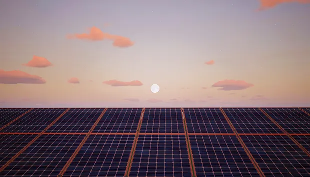 Solar panels at sunset with the sun low on the horizon and scattered clouds in the sky.