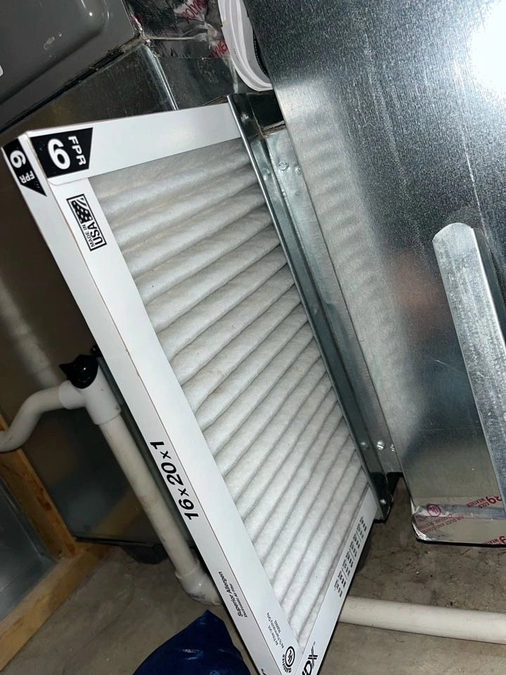 Air filter partially inserted into an HVAC unit. 