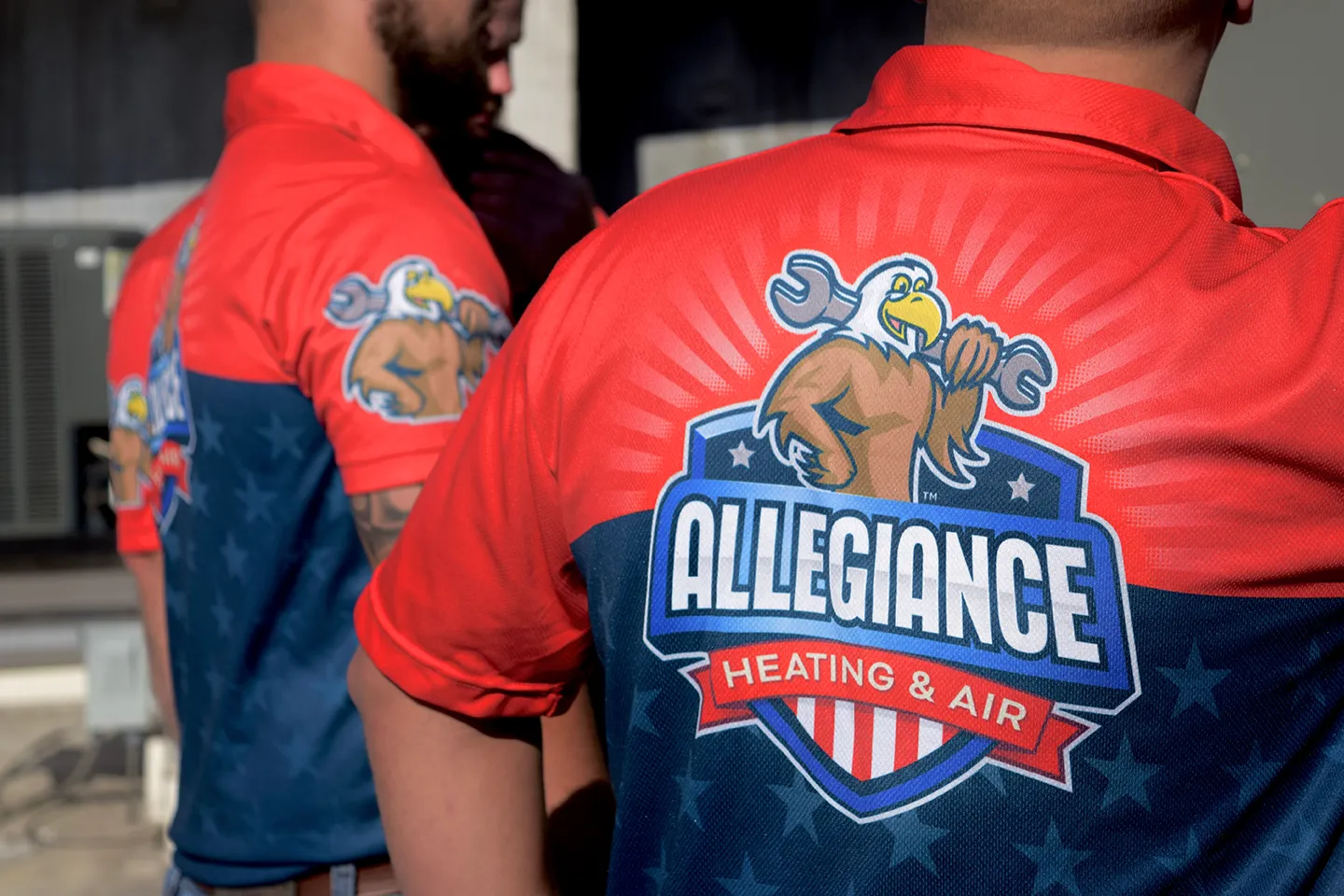 Technicians from Allegiance Heating & Air wearing branded uniforms with logo, showcasing HVAC expertise and professionalism.