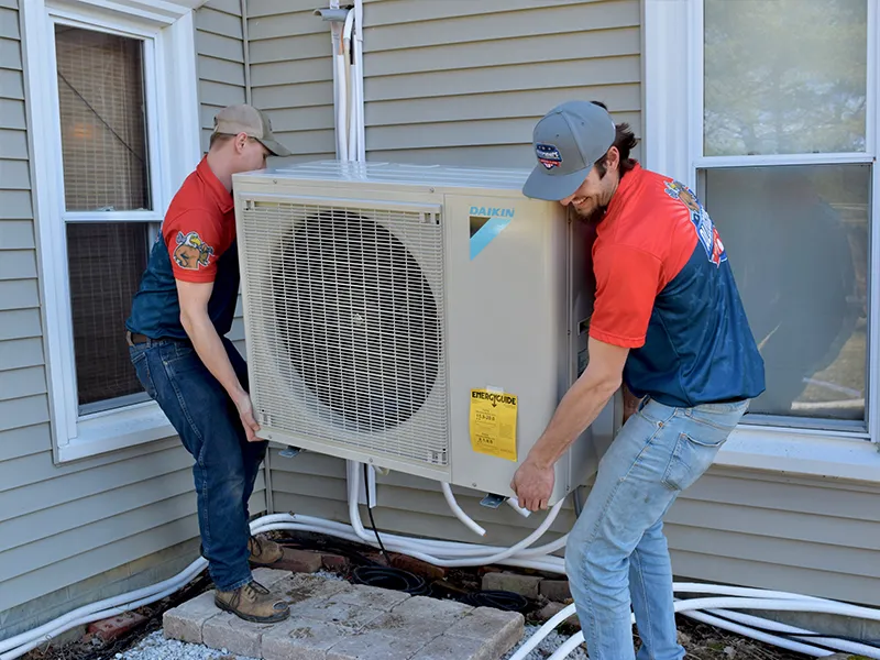 Technicians installing a Daikin air conditioning unit outside a home, showcasing HVAC installation services relevant to energy efficiency and comfort in residential settings.