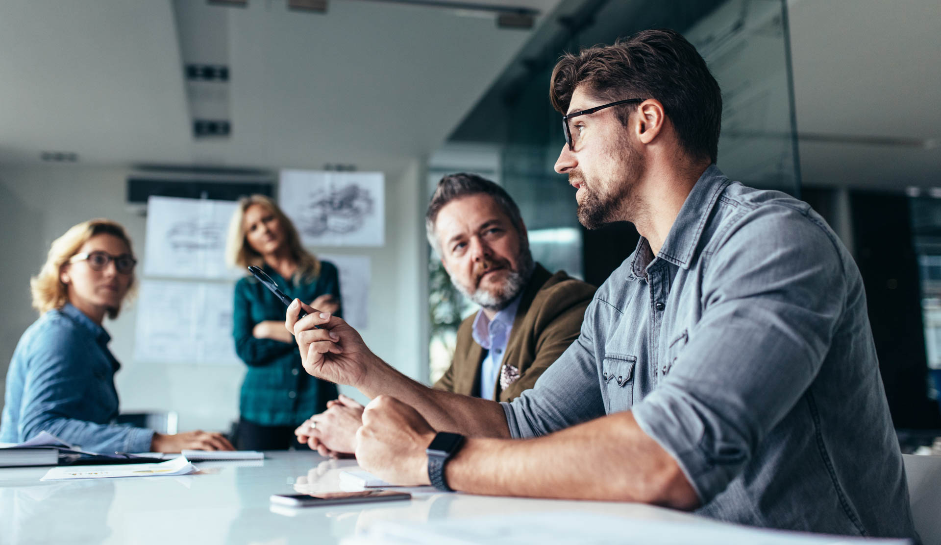 a group of people sitting on a table having a team discussion