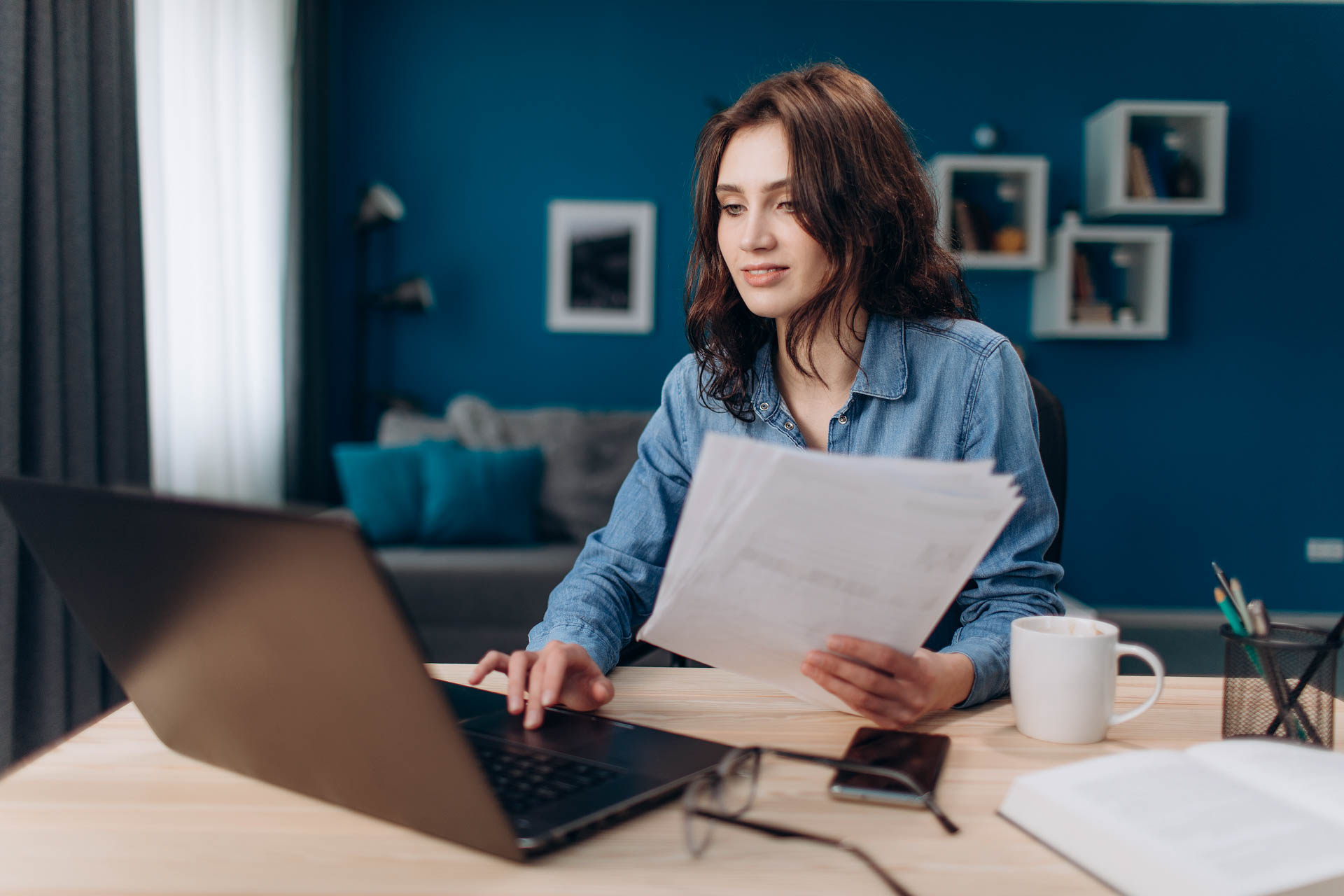 a women working on a desk with a laptop