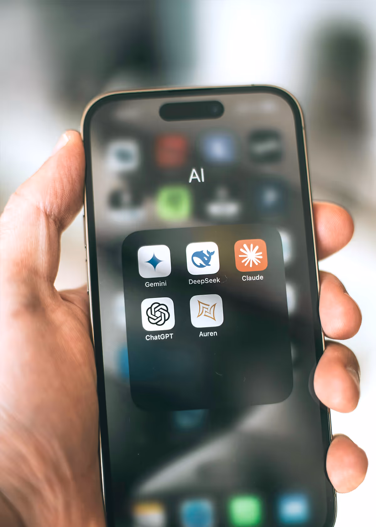 hand mit Smartphone, KI Icons von ChatGPT, Claude und anderen KIS ist sichtbar