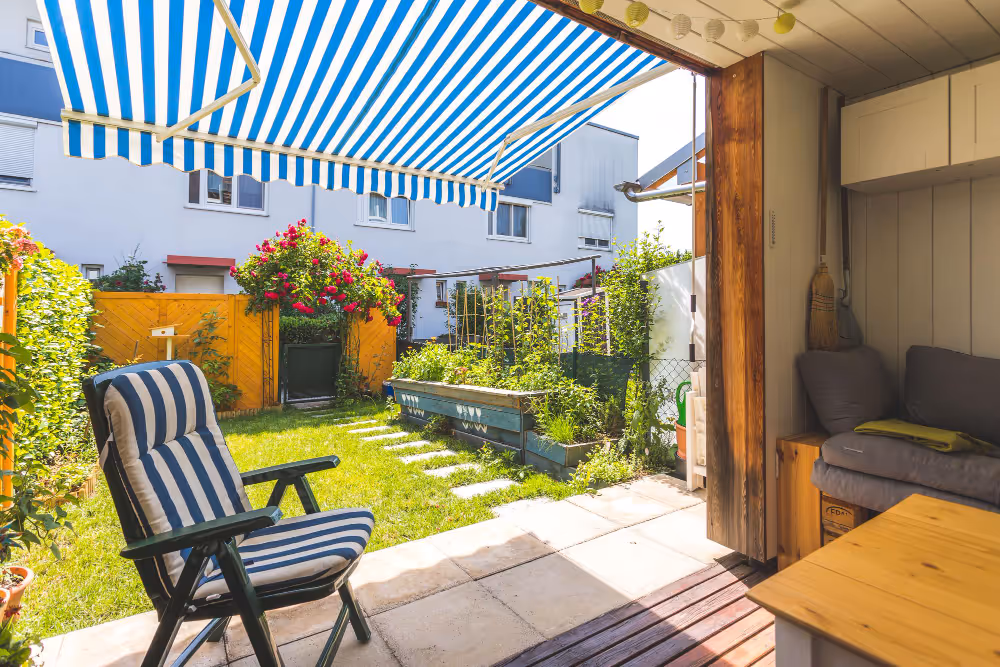 Eine Markise als Sonnenschutz auf einer Terrasse mit einem Liegestuhl