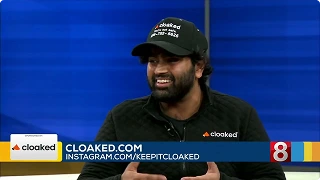 Man wearing a black cloaked shirt and hat smiling during a broadcast with cloaked.com and social media handle on screen.