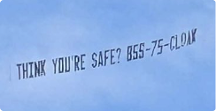 Sky banner with text 'THINK YOU'RE SAFE? 855-75-CLOAK' flying against a blue sky.