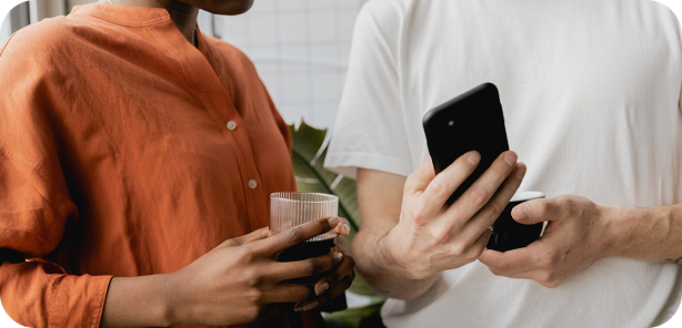 Smiling woman working on a laptop in a bright, modern cafe with large windows.