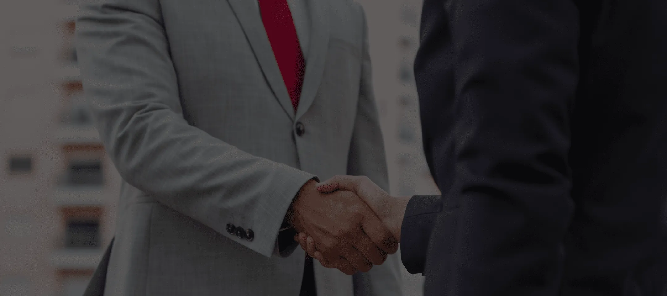 Due uomini in giacca che si stringono la mano durante un incontro professionale.
