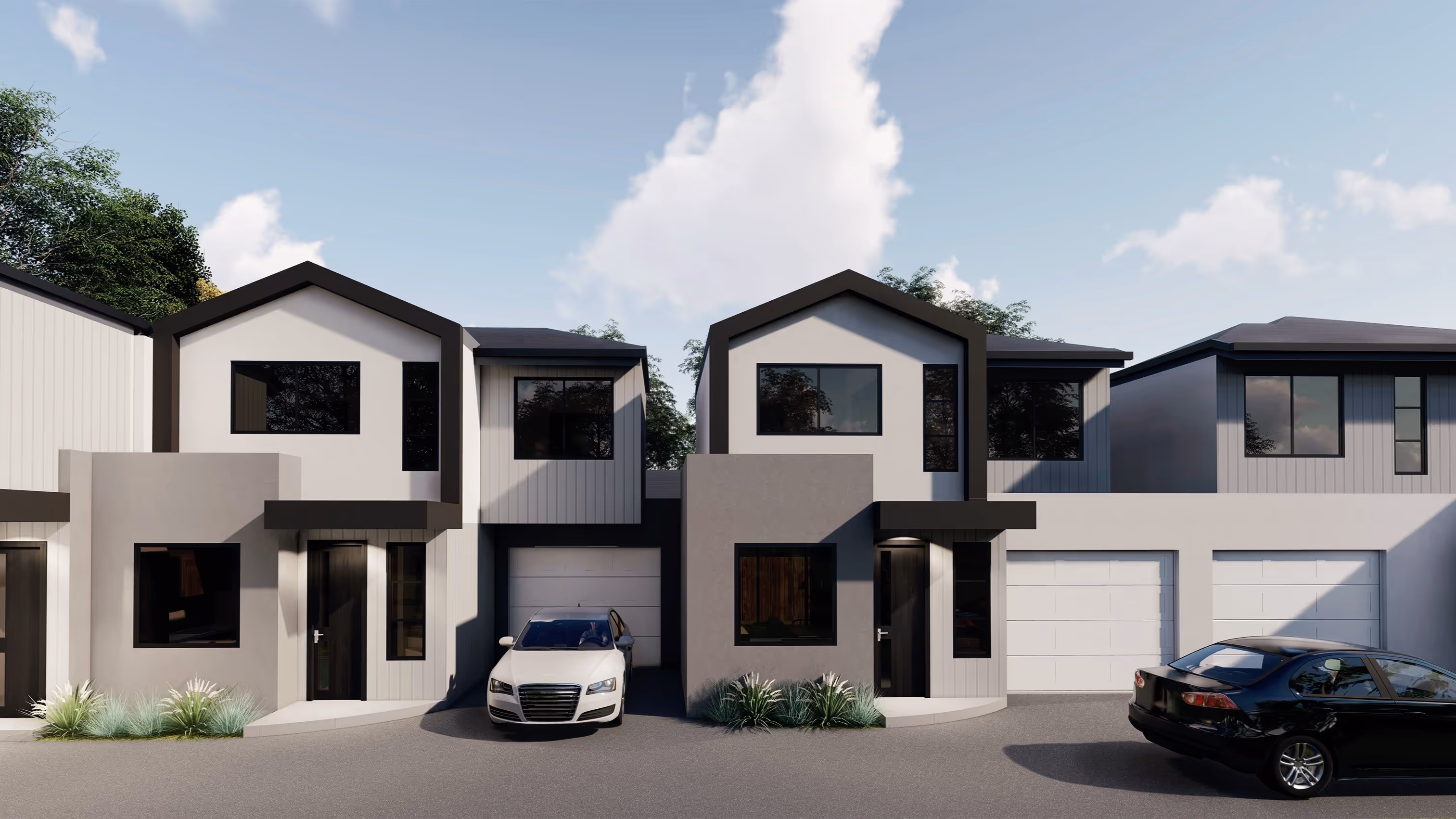Modern two-story townhouse units with siding and large windows, each featuring a garage and driveway with parked cars.