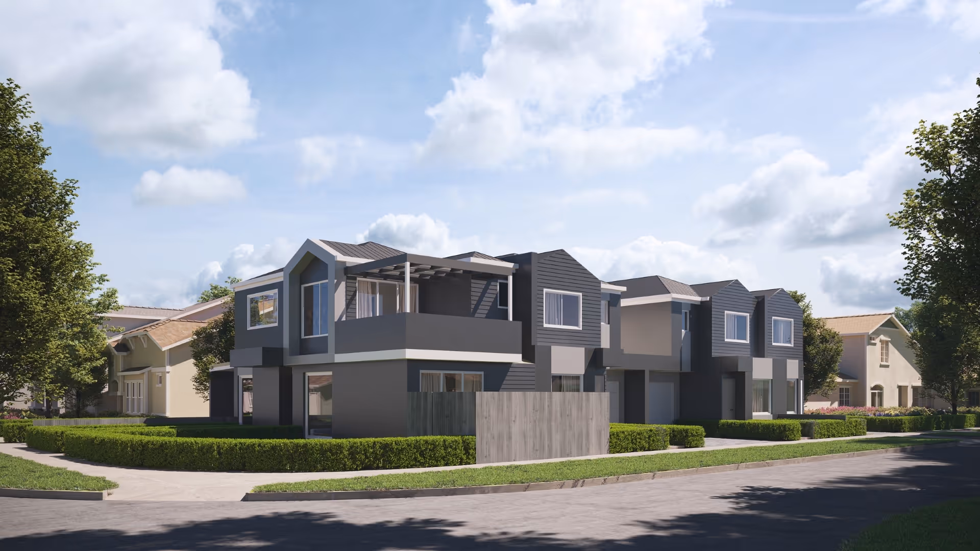 Modern two-story houses with dark exteriors, balconies, hedges, and trees under a partly cloudy sky.