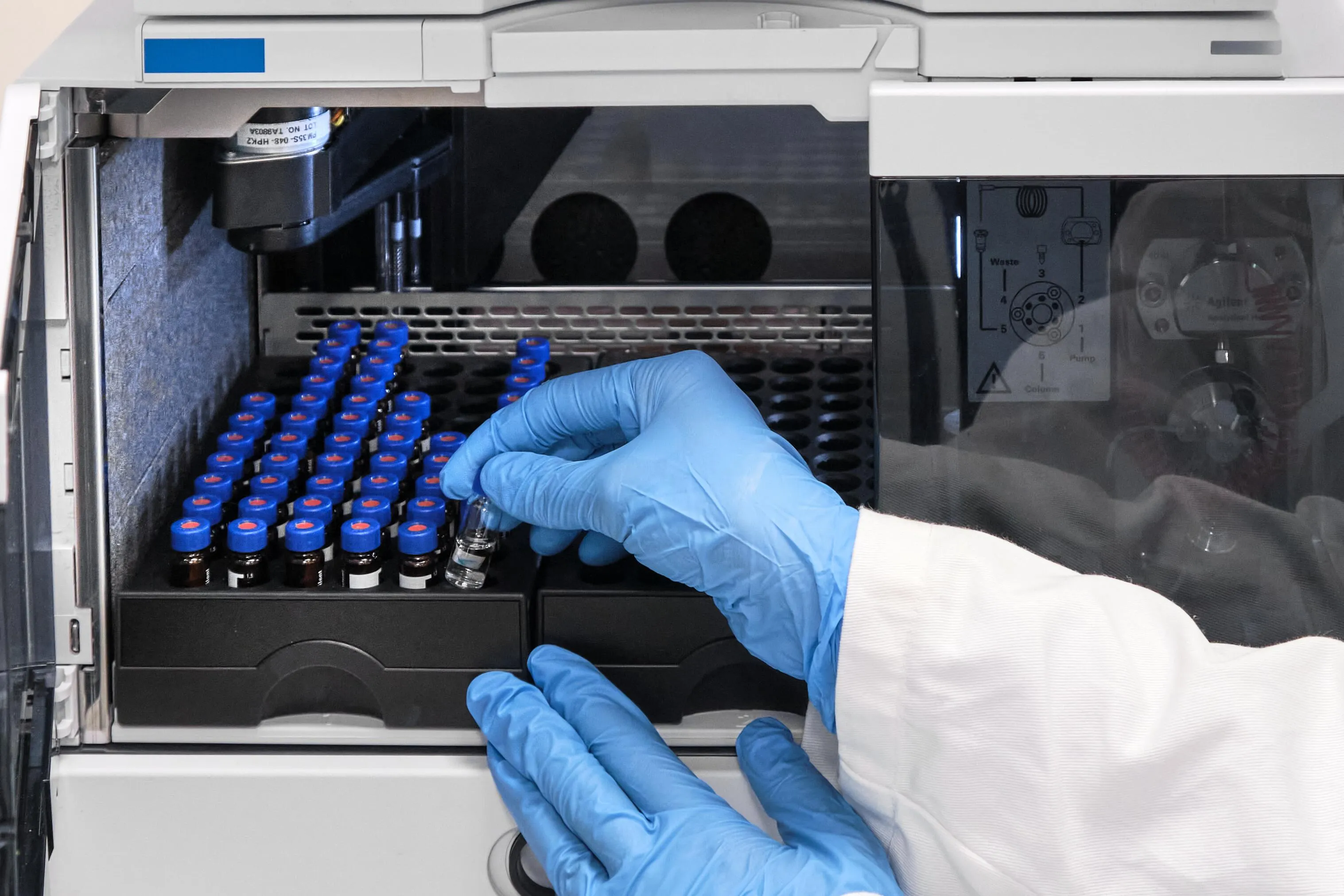 Forskare vid HPLC-instrument i laboratorium.