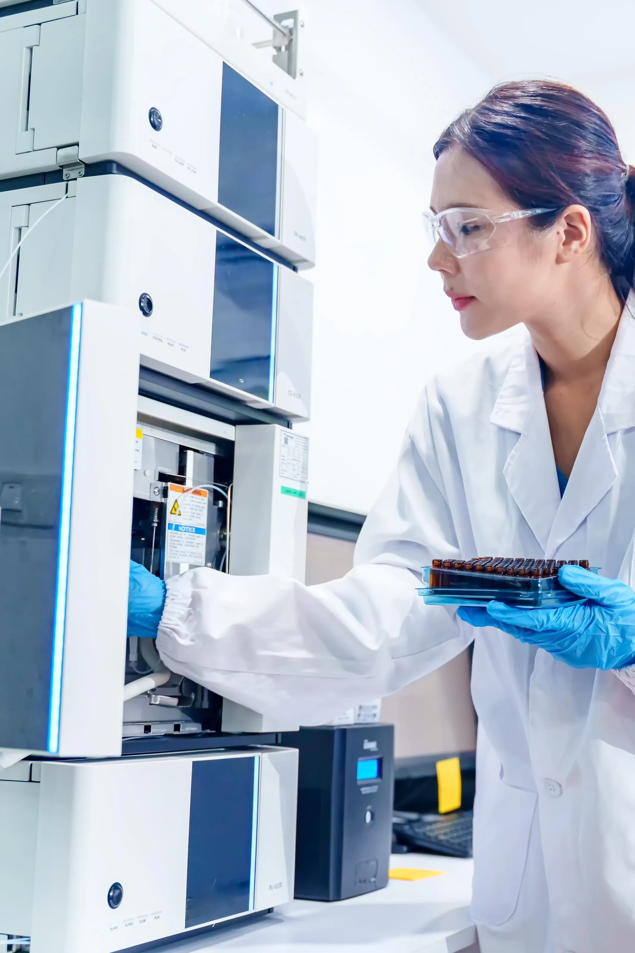 Analytiker arbetar med kromatografiutrustning i laboratorium.