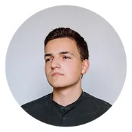 Portrait of a young man with short dark hair, wearing a dark buttoned shirt, looking slightly to the side.