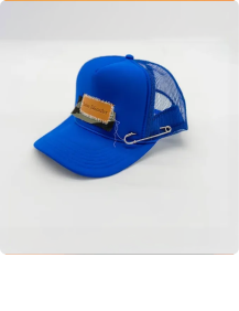 Blue mesh baseball hat with a brown leather patch and a large safety pin attached.