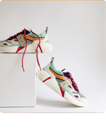 Pair of colorful modern sneakers with red laces displayed on white platform against a light background.
