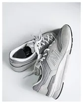 Pair of gray New Balance sneakers with white laces on a white background.
