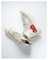 Pair of white high-top sneakers with a red heart logo featuring eyes on the outer side.