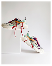 Pair of colorful sneakers with red and purple laces displayed against a plain white background.