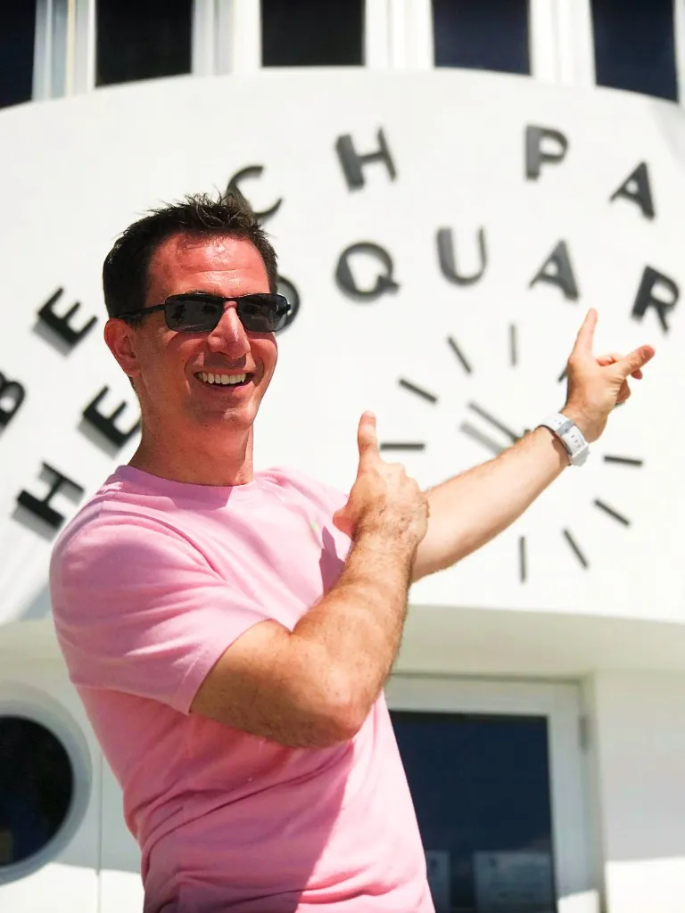 A smiling tour customers pointing to the Miami Beach Patrol Art Deco Building