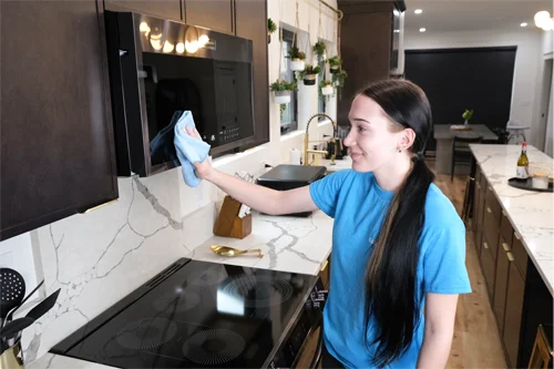 cleaner wiping a microwave