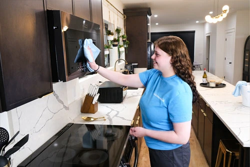 cleaner wiping a microwave