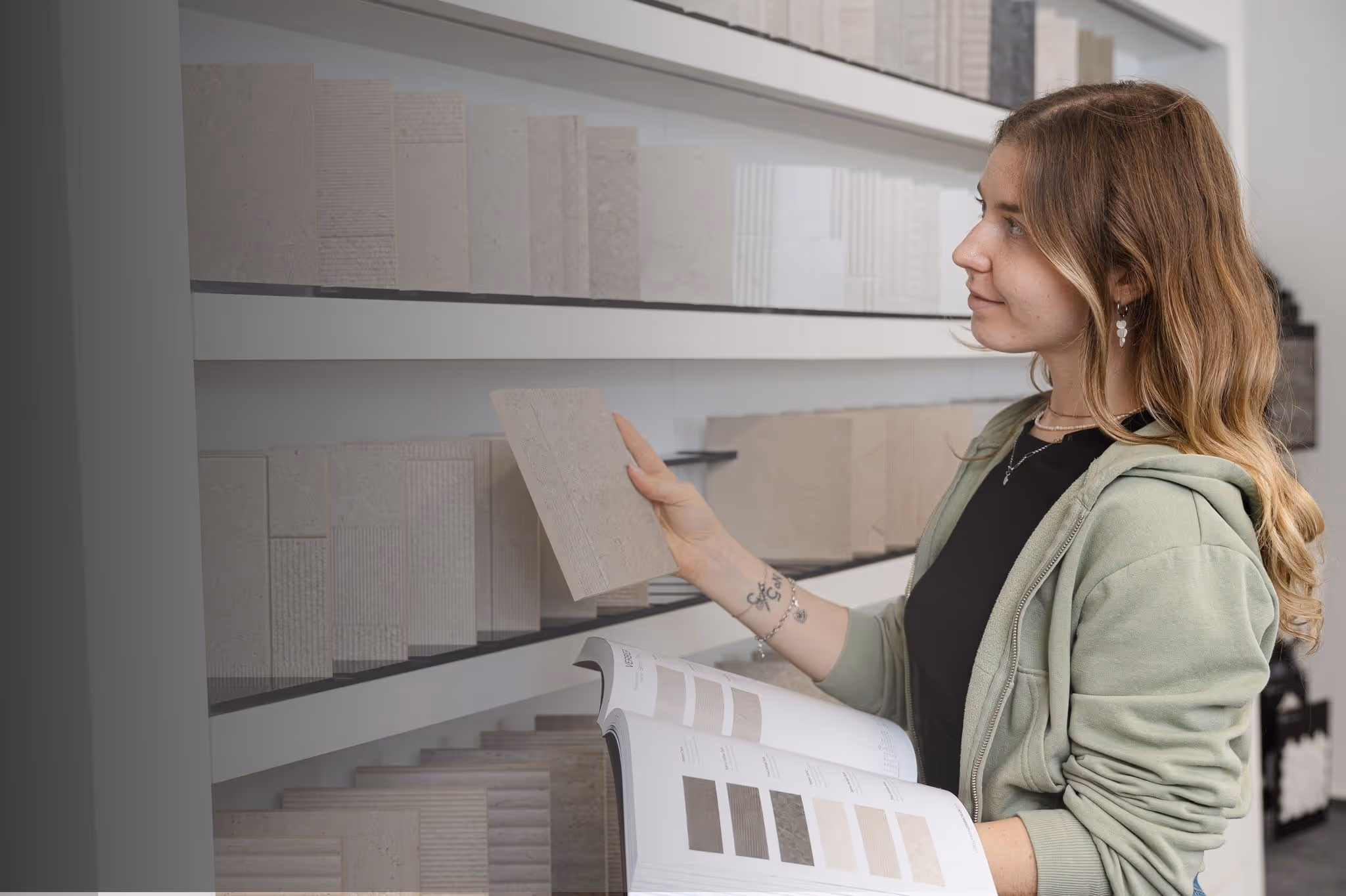 Eckel Mitarbeiterin an einer Austellungswand mit Badfliesen