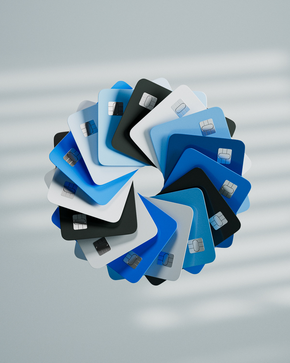 Array of blue, black, and white credit cards arranged in a circular spiral pattern on a gray background.