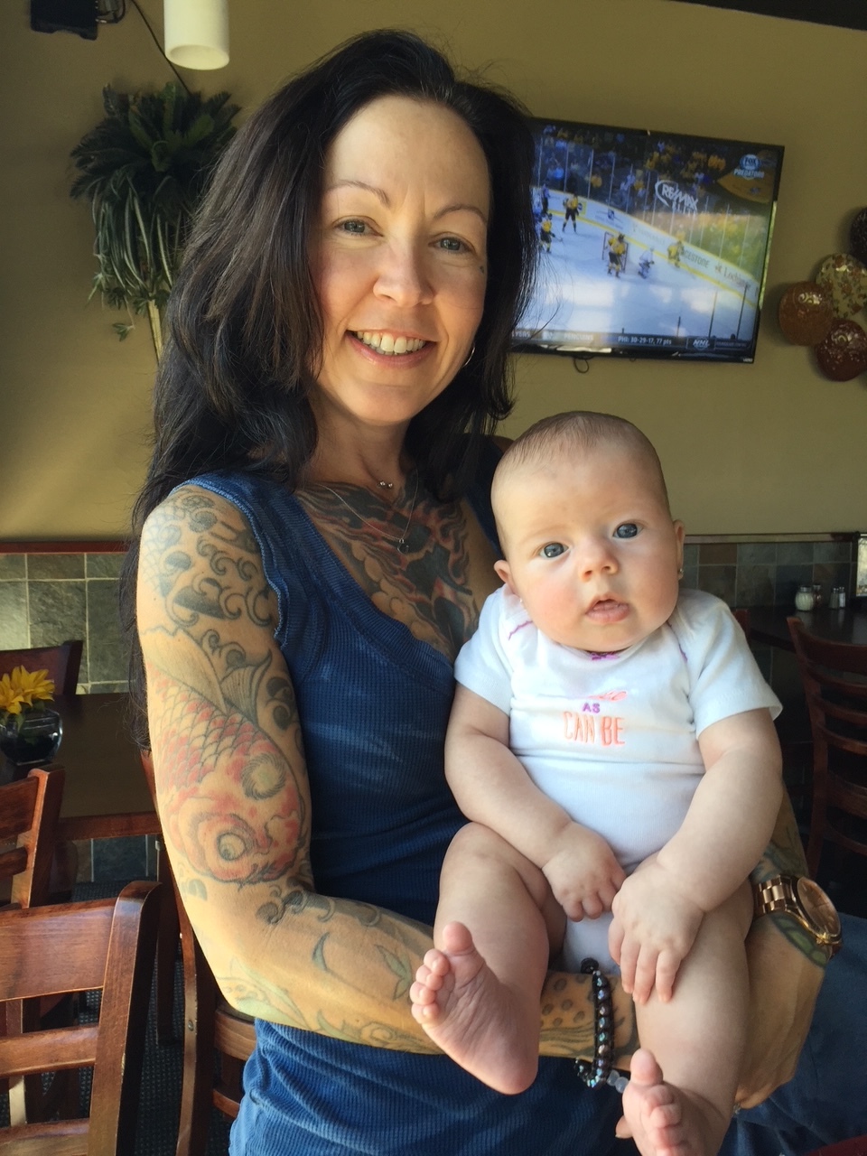 Jana Van Dyck smiling and holding a baby