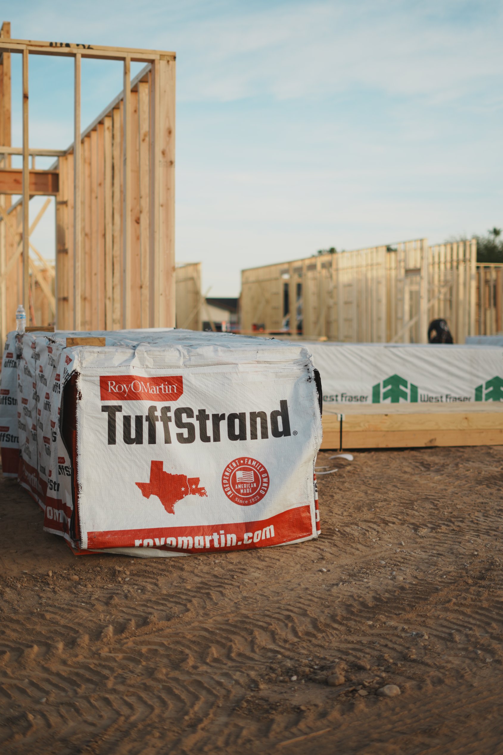 TuffStrand packaged wood product by RoyOMartin on a construction site with wooden frames and dirt ground.