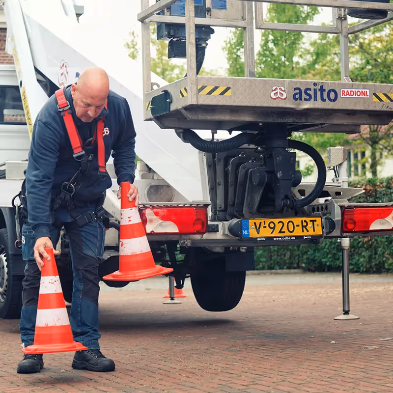 Reiniging van staalconstructie in stationsomgeving, veilig uitgevoerd binnen afgezette zone.