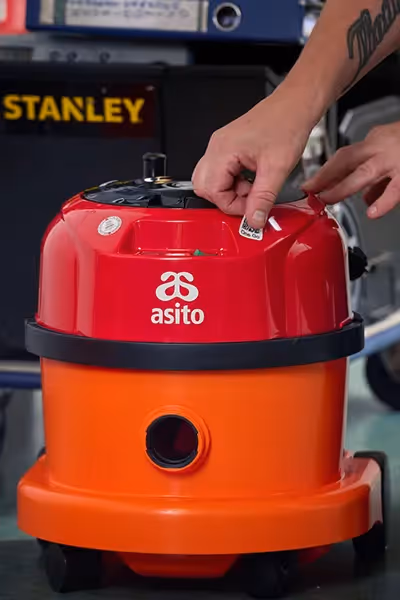 Asito-medewerker keurt een schrobmachine op locatie en registreert de resultaten in One Go.