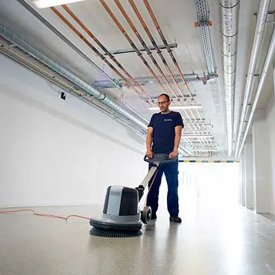 Medewerker Asito maakt vloer schoon