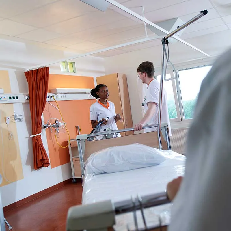 Medewerkers Asito maken ziekenhuisbed schoon