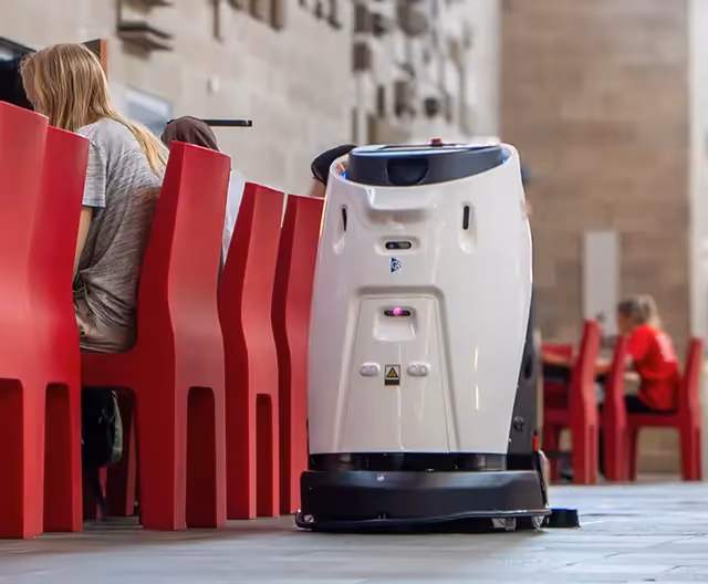 Een robot reinigt de vloer in een drukbezochte ruimte, voor een altijd schone en representatieve omgeving
