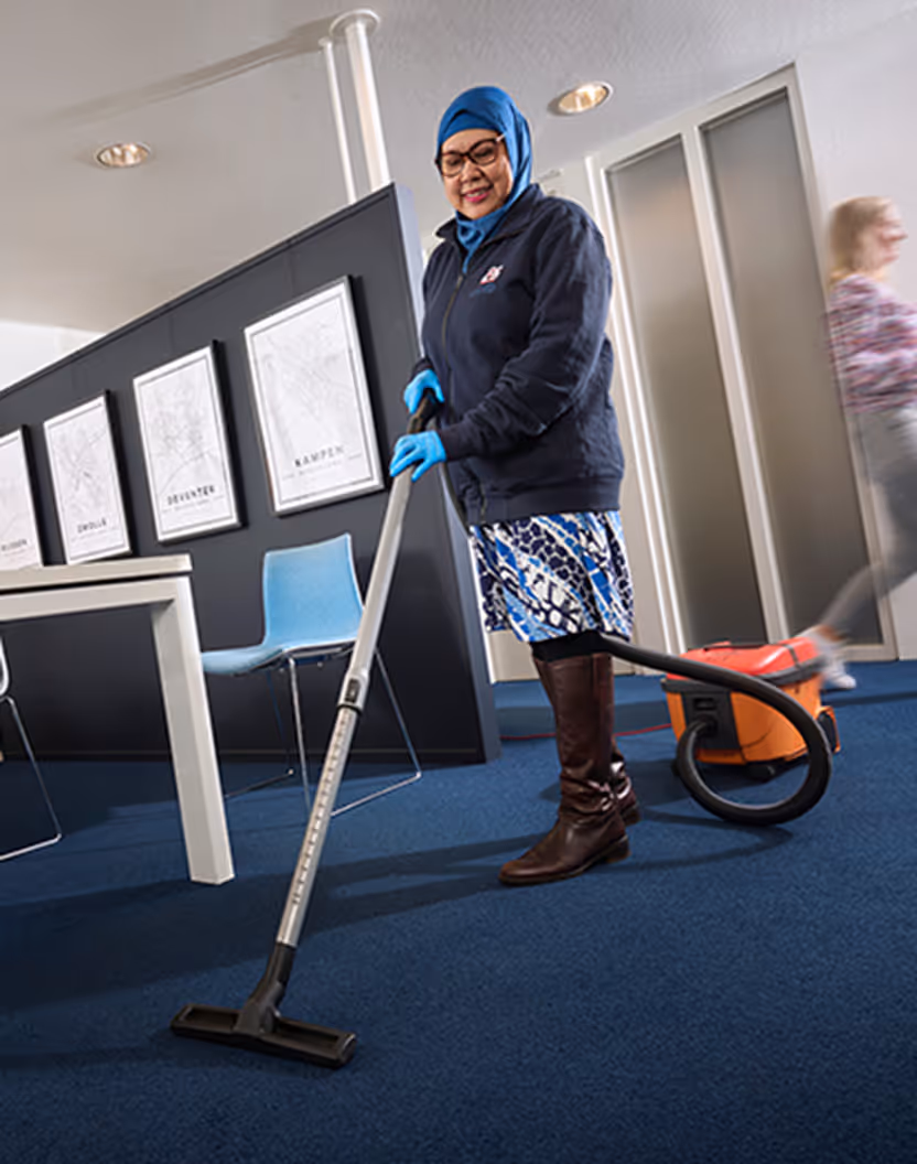 Asito medewerker reinigt een werkplek voor een frisse en verzorgde uitstraling.