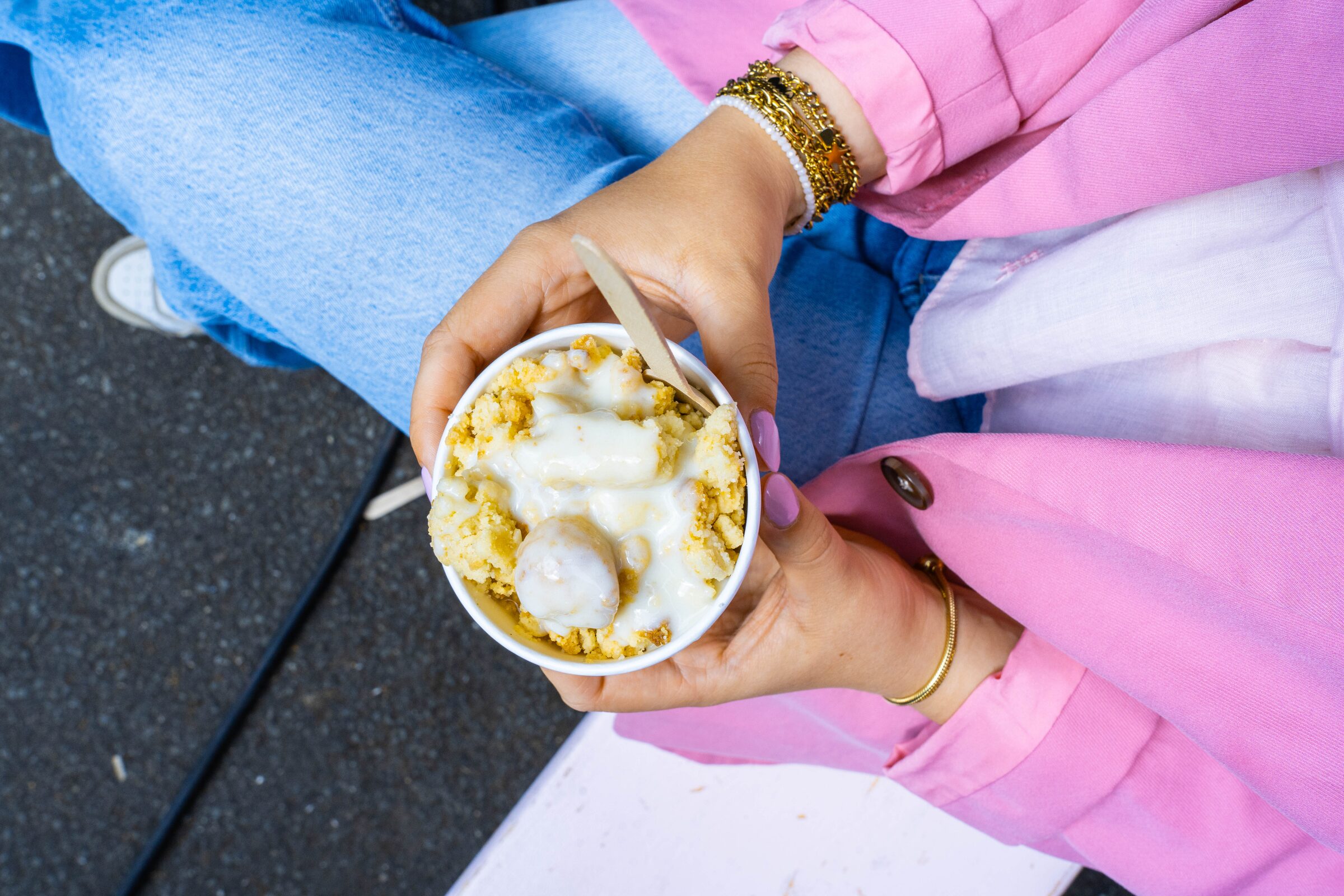 Gast hält einen Becher warmen Crumble mit Vanillesauce – Dessert-Catering der Crumble Bar in Hamburg