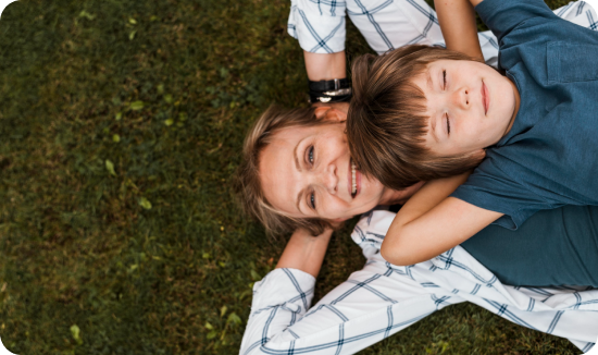 Mother laying on the grass with her son