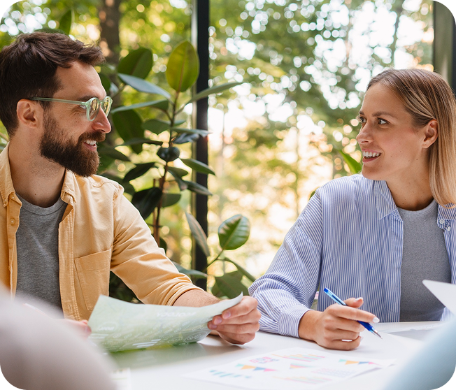 Man and woman talking while holding pen and paper