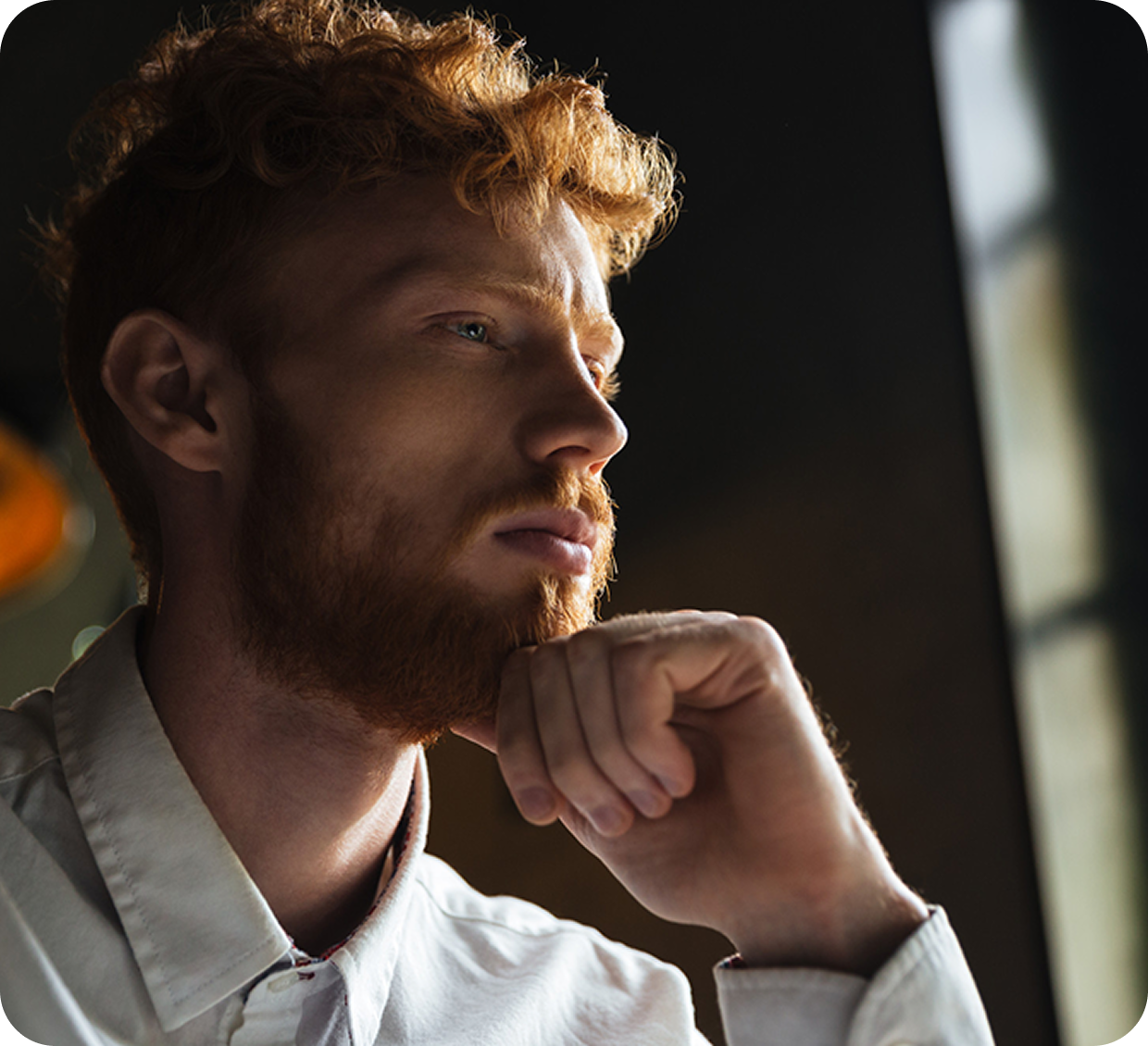 Man thinking while holding his chin