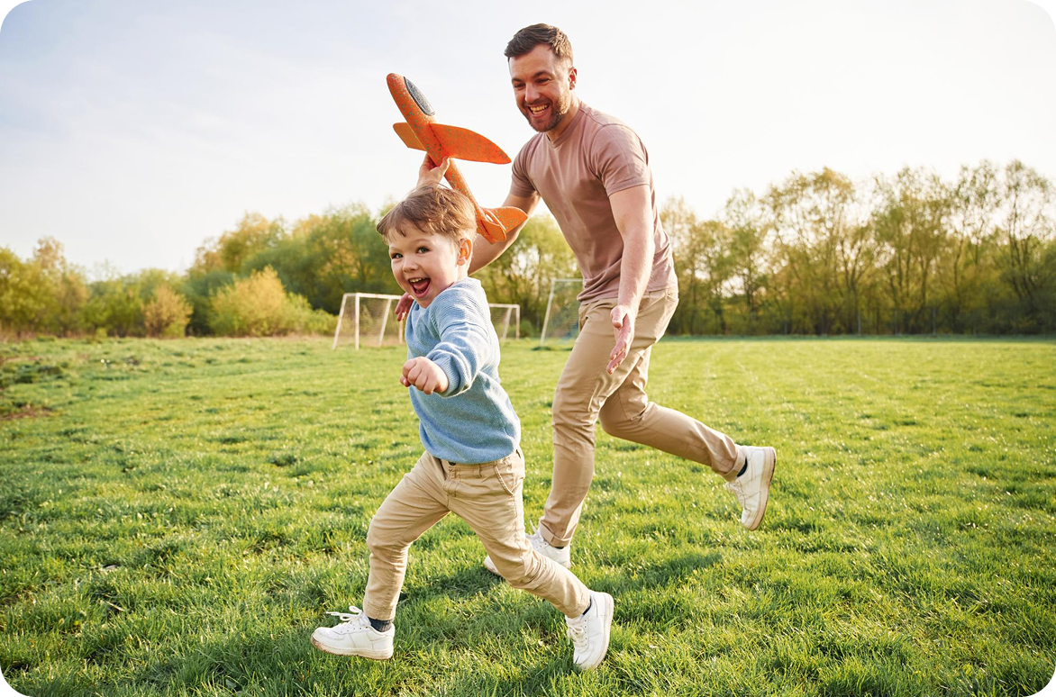 Father and son playing in a football field