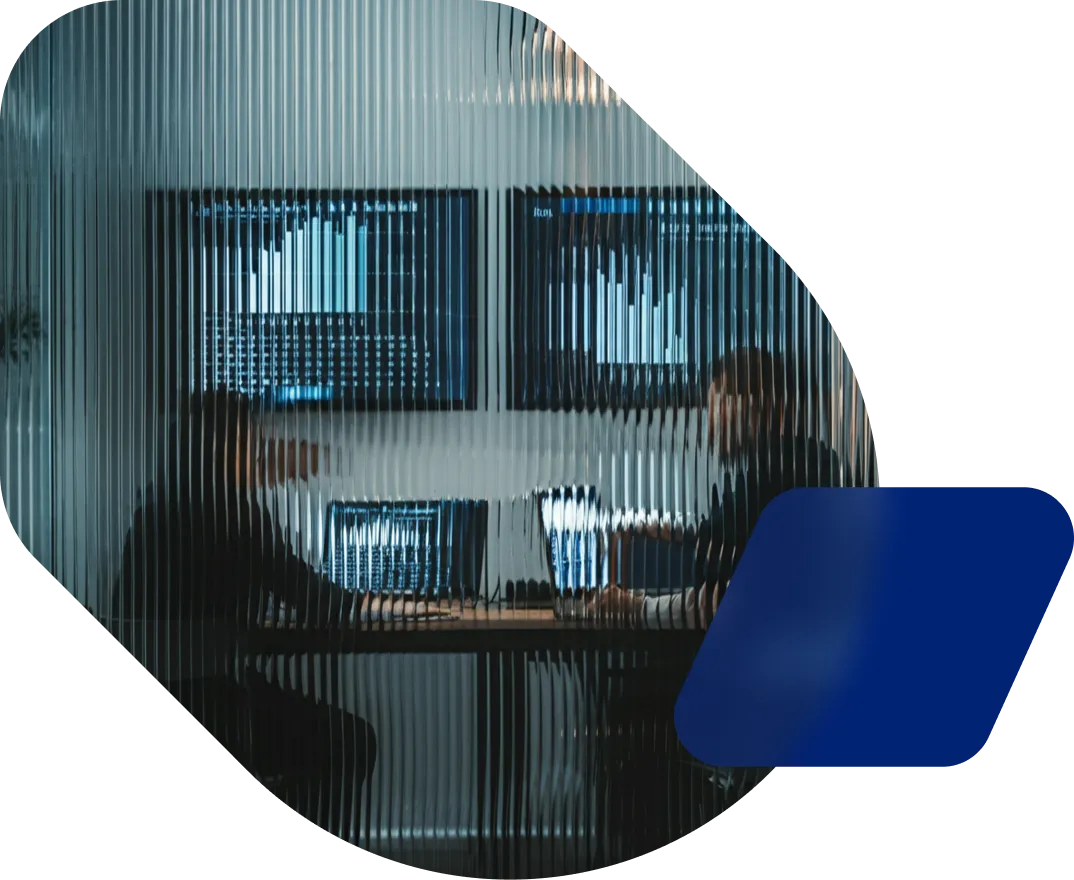 A man sitting at a desk in front of a computer monitor.