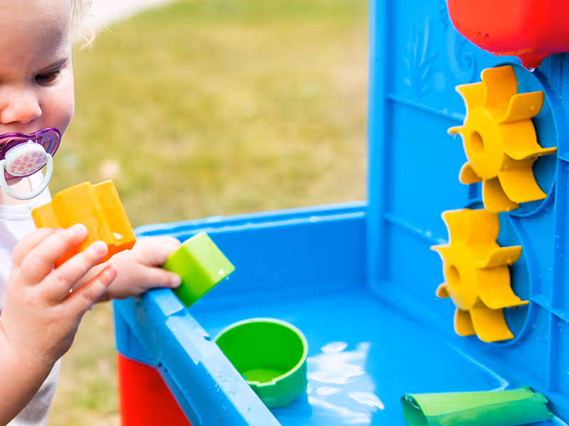 toddler playing with water table