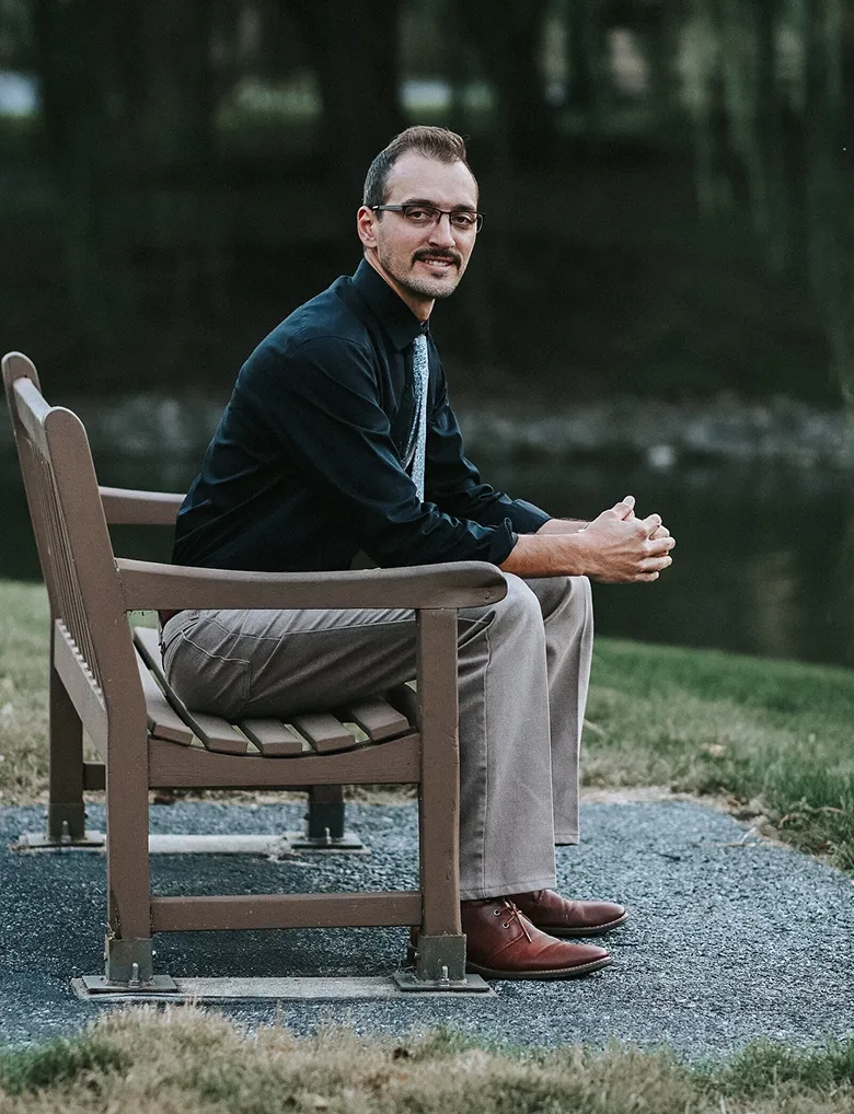 Marcus Ebersol, founder of Project Eight Co. posing at a park bench