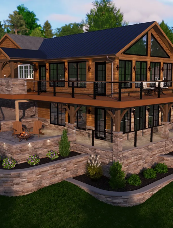 Two-story wooden house with large windows, upper and lower stone patios, a metal roof, outdoor seating area with a fire pit, and landscaped garden beds.