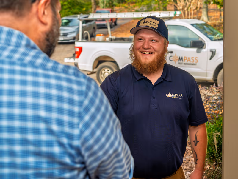 compass pest management tech greeting a pest control customer
