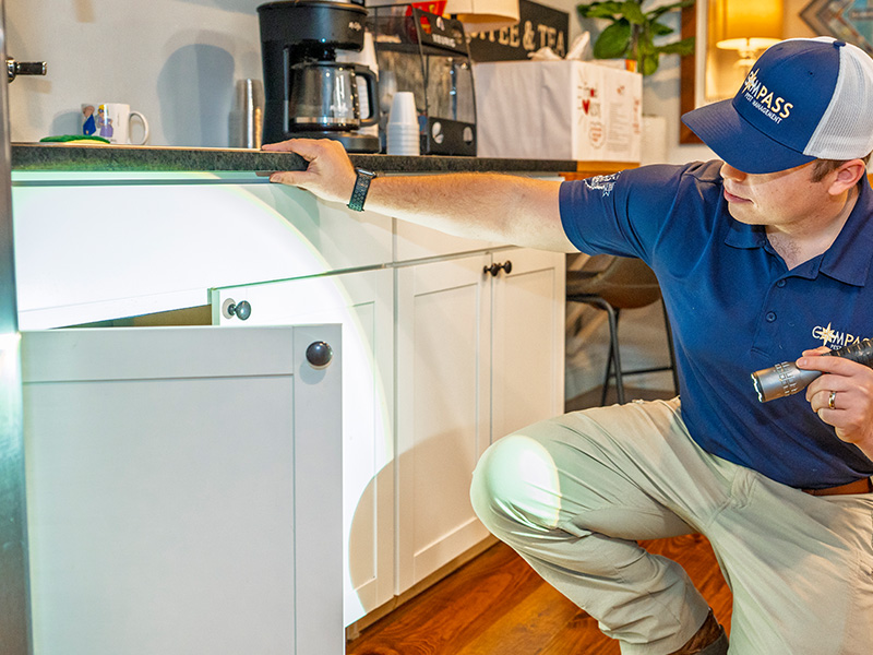 pest tech looking under a counter