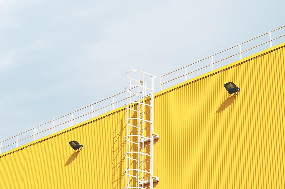 white ladder on yellow building exterior