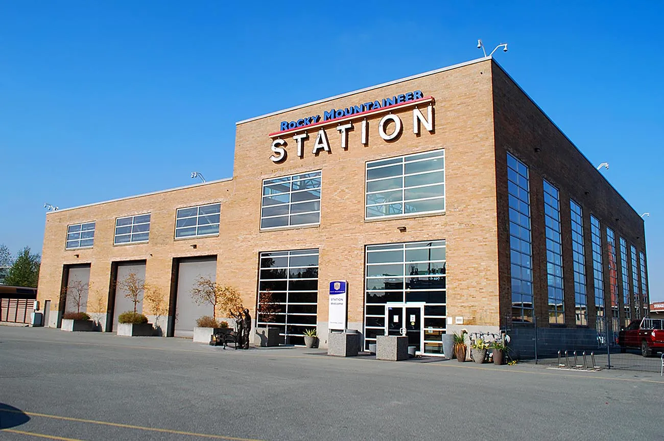 Brick building with large windows labeled 'Rocky Mountaineer Station' under clear blue sky.