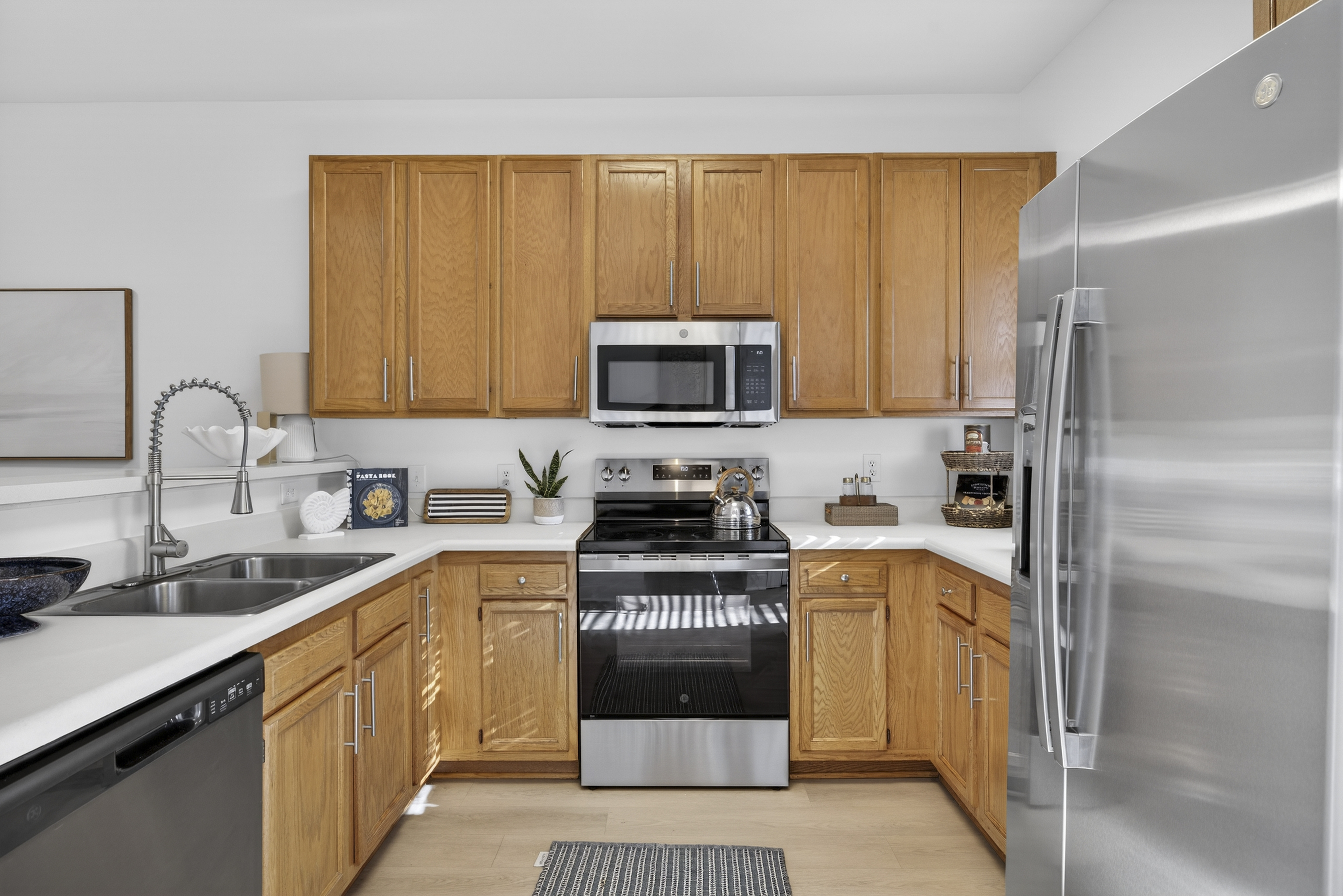 Large kitchen space with dishwasher, refrigerator, and range.