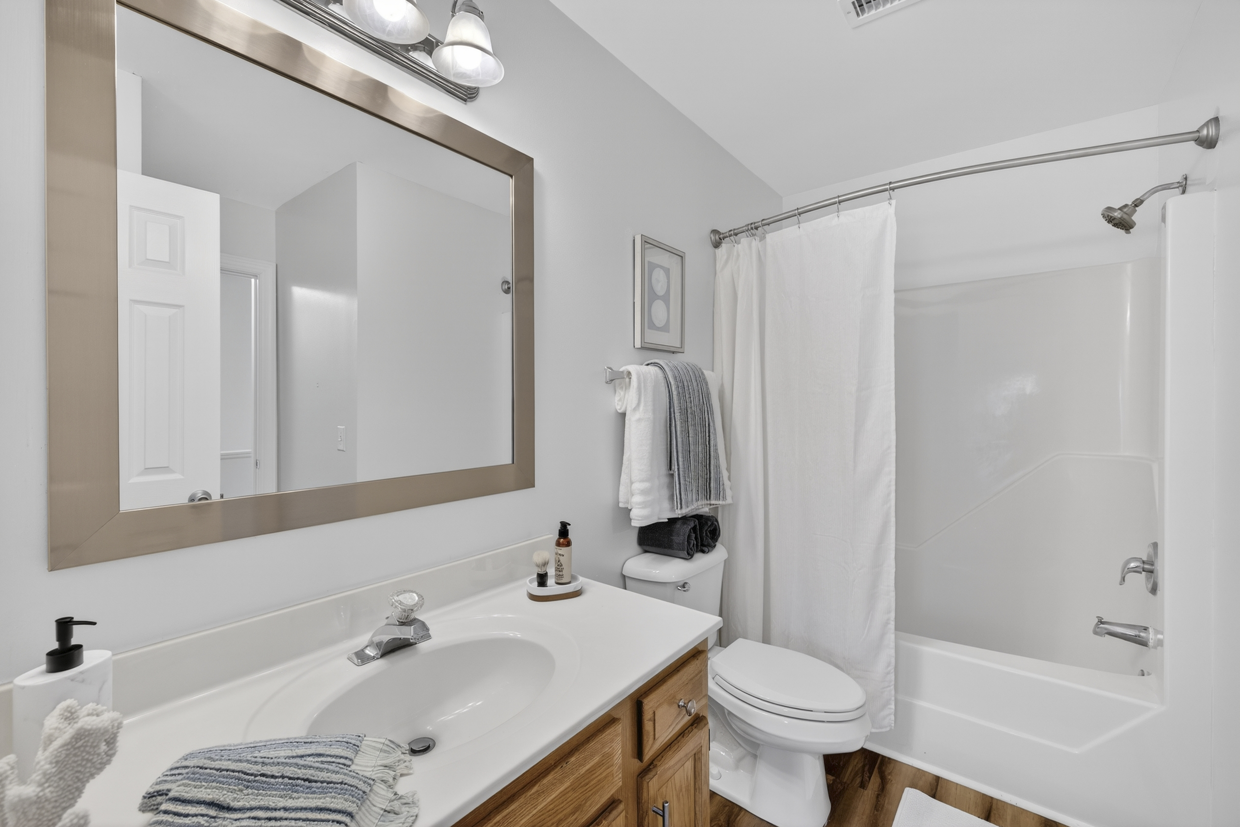 Large, framed mirror in bathroom with tub and shower in every townhome.